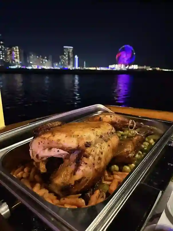Spectacular nighttime view of a dhow cruise party on the water, with tasty food and a lively atmosphere